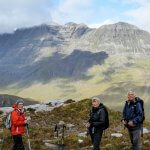 Three hikers admire Scotland's mountains